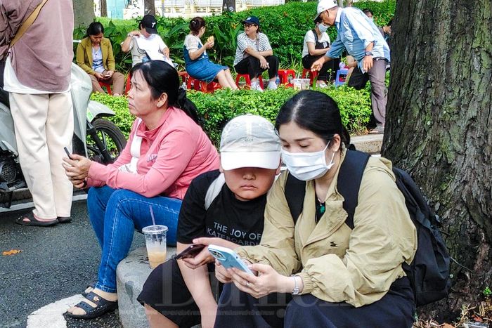 Sau khi con em đã vào phòng thi, khá đông phụ huynh ngồi lại ngóng chờ con tại các điểm thi.
