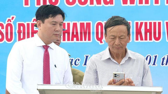 Chủ tịch UBND phường Bạc Liêu Lê Việt Xô (bên trái) hướng dẫn người dân truy cập hệ thống Wifi miễn phí để tìm kiếm thông tin địa phương.