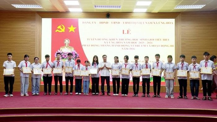 Lãnh đạo Đảng ủy, HĐND, UBND xã Ứng Hòa trao thưởng cho các học sinh tiêu biểu. Ảnh: Lê Quí