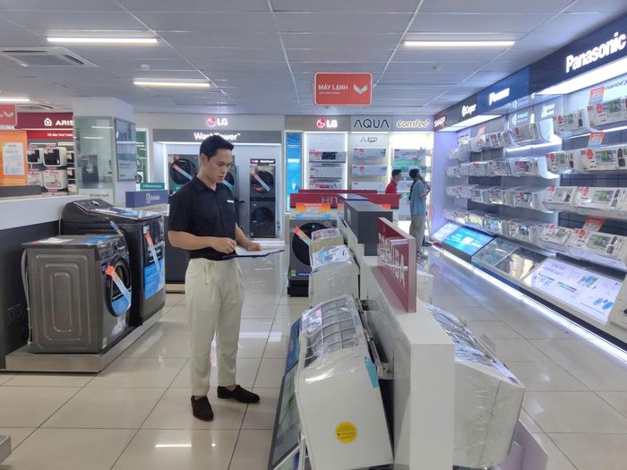 Giám đốc Trung tâm mua sắm Nguyễn Kim (Tràng Thi) Vũ Đồng Tiến kiểm tra các sản phẩm để phục vụ khách hàng. Ảnh: Khắc Kiên
