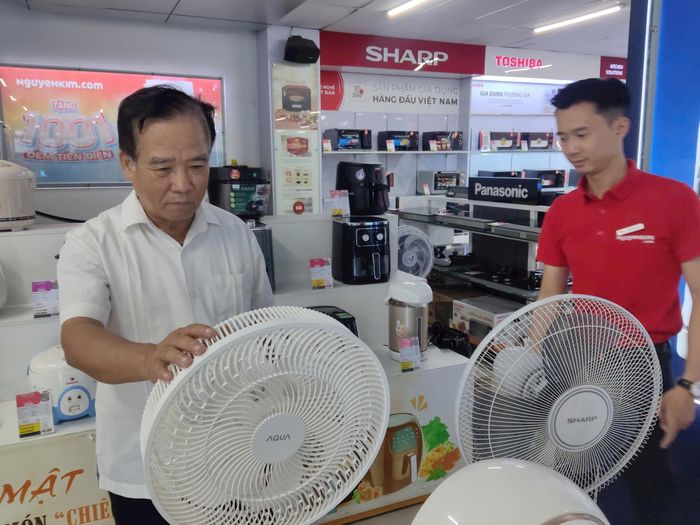 Ông Phạm Ngọc Lan, cư dân phường Hoàng Liệt, thành phố Hà Nội đang tìm hiểu các dòng sản phẩm quạt để lựa chọn mua. Ảnh: Khắc Kiên