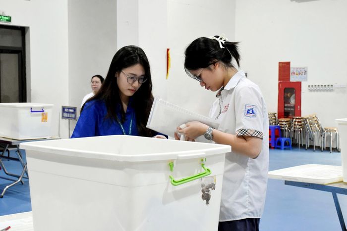 Sinh viên tình nguyện hỗ trợ thí sinh tại điểm thi Trường THCS Thành Công (phường Giảng Võ). Ảnh: Phạm Thảo.