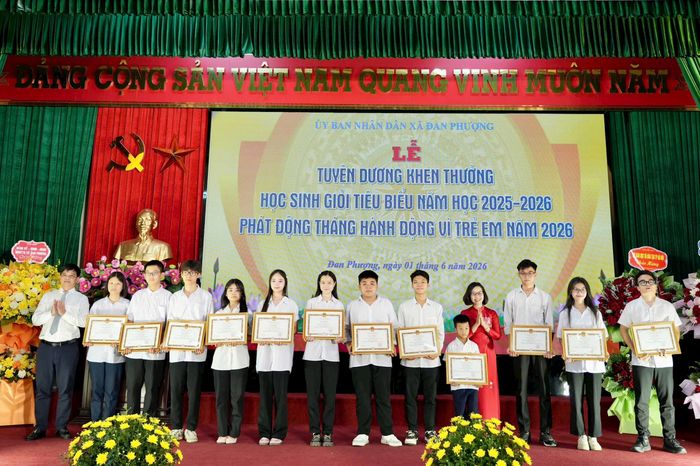 Phó Bí thư Thường trực Đảng ủy xã Đan Phượng Nguyễn Thị Hiền và Chủ tịch UBND xã Nguyễn Viết Đạt trao khen thưởng cho các học sinh tiêu biểu. Ảnh: Ngân Nguyễn