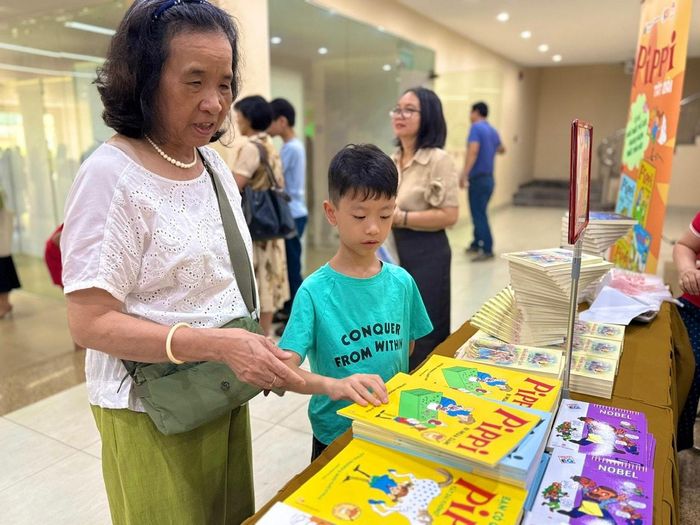 Bà Nguyễn Thị Kim Bình và cháu trai Nguyễn Minh Tâm, 8 tuổi, lựa chọn những cuốn truyện Pippi Tất Dài. Ảnh: Kiều Thoan Thu