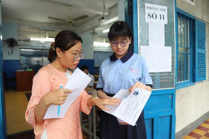 Cán bộ coi thi kiểm tra thông tin thí sinh trước khi vào phòng thi.