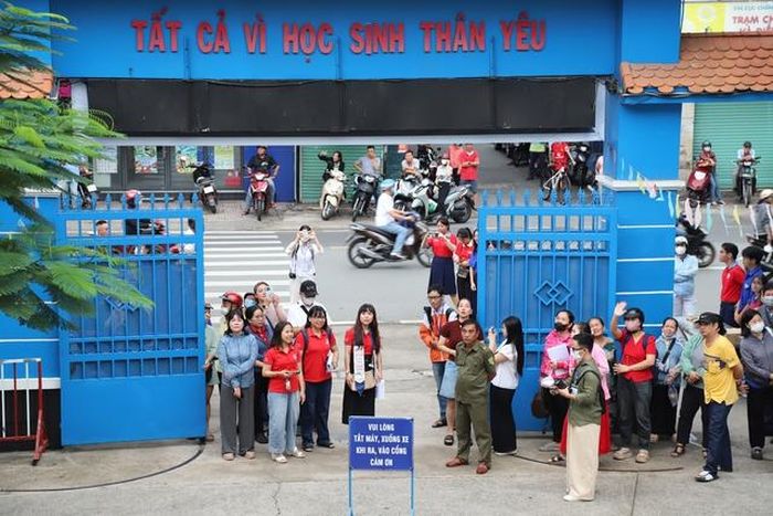 Dù các thí sinh đã vào phòng thi nhưng nhiều phụ huynh, giáo viên vẫn lo lắng đứng chờ trước điểm thi. Ảnh: Phạm Thương.