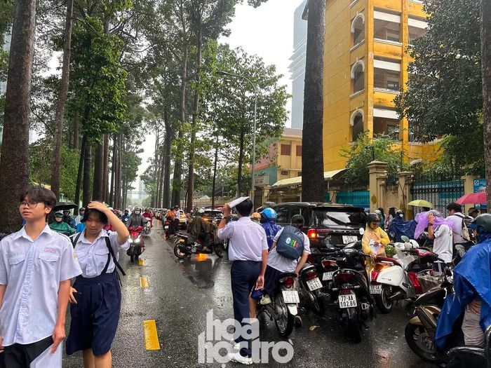 Thí sinh ra về trong cơn mưa, kỳ thi tuyển sinh vào 10 chính thức kết thúc. Ảnh: Văn Thuận.