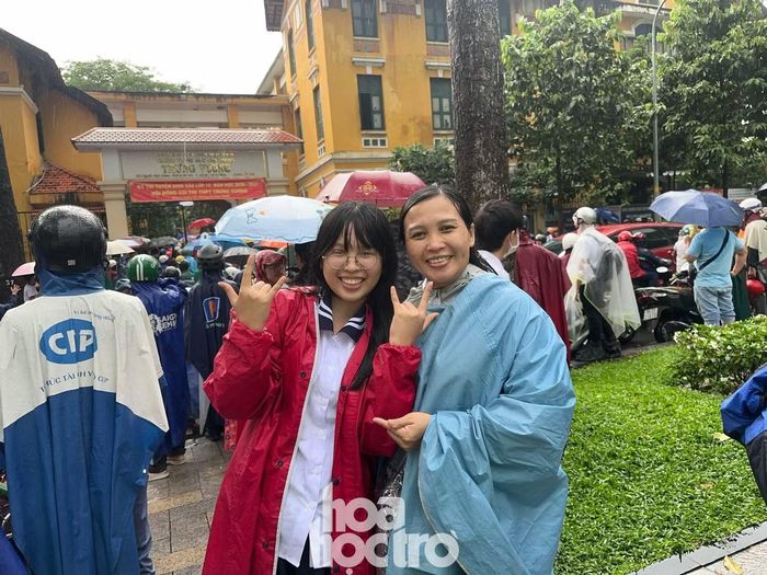 Bảo Trân và mẹ cùng đội mưa "vượt vũ môn". Ảnh: Văn Thuận.