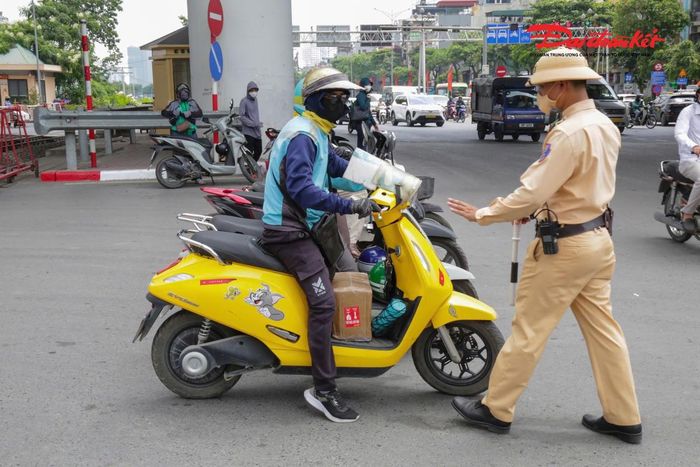 Tổ công tác phát hiện lái xe ôm công nghệ L.M.V. (SN 1993, ở Hà Nội) điều khiển xe máy mang BKS 35B1-941.xx có hành vi vượt đường ngang khi đèn đỏ đã bật sáng. Ngay lập tức một cán bộ CSGT đứng tại chốt chặn phía bên kia đường đã yêu cầu tài xế dừng xe để xử lý.