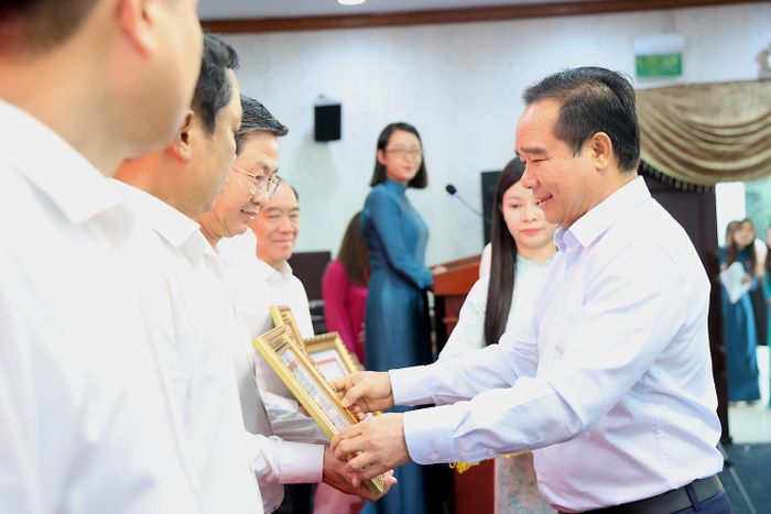  Ông Nguyễn Văn Được, Ủy viên Trung ương Đảng, Chủ tịch UBND TP.HCM, tặng bằng khen cho các sở, ngành có thành tích xuất sắc, có sáng kiến trong việc đẩy nhanh tiến độ giải quyết hồ sơ, tháo gỡ khó khăn vướng mắc. Ảnh: LÊ THOA 