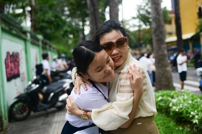  Chị Tường Vi ôm con gái Hồng Ngọc sau buổi thi sáng 2/6. "Tôi không hỏi cụ thể cháu làm thế nào. Hôm qua thi xong 2 môn, 2 mẹ con ngồi tính toán thì chỉ cần 7 điểm toán là sẽ đạt nguyện vọng 1. Tôi nói con không cần quá căng thẳng, không cần quá sức", chị Tường Vi chia sẻ. 