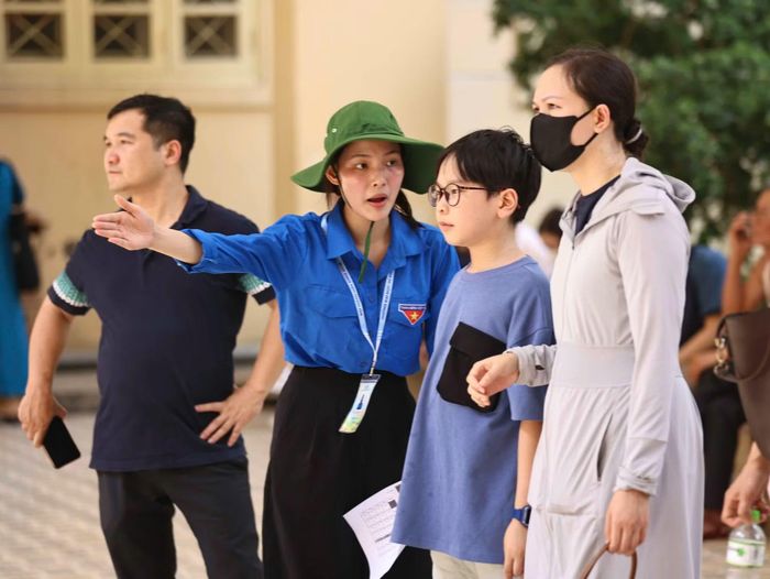 Thanh niên tình nguyện hỗ trợ hướng dẫn thí sinh vào phòng thi.