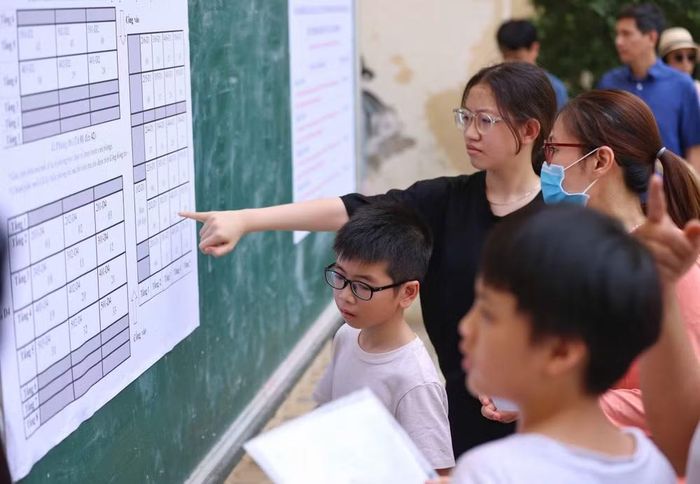 Thí sinh và phụ huynh xem sơ đồ phòng thi. (Ảnh: THANH TÙNG)