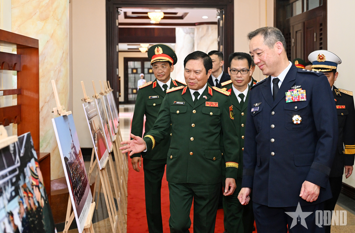 Đại tướng Nguyễn Tân Cương giới thiệu với Đại tướng Uchikura Hiroaki một số hình ảnh về hợp tác quốc phòng giữa Việt Nam và Nhật Bản. 