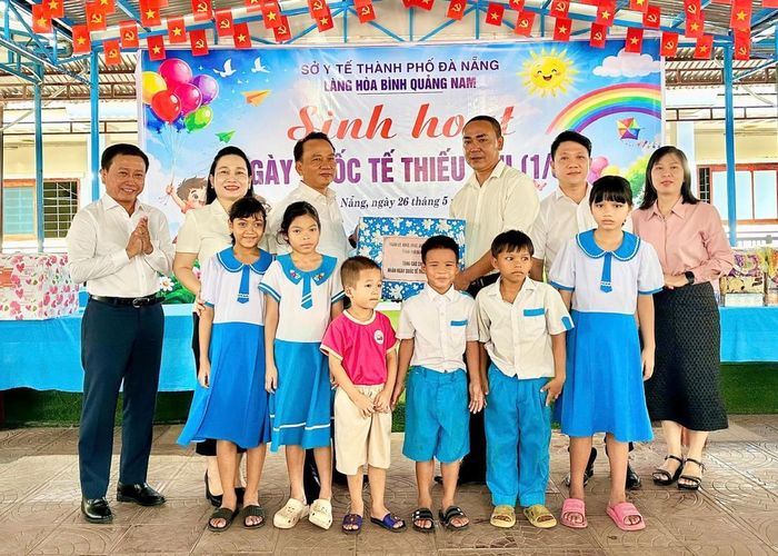 Phó Bí thư Thường trực Thành ủy Nguyễn Đình Vĩnh trao quà cho lãnh đạo Làng Hòa Bình Quảng Nam.