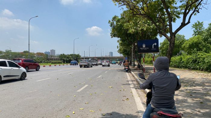 Người dân dừng dưới những bóng cây để tránh nắng khi chờ đèn đỏ ở ngã tư đường Lê Quang Đạo và Đại lộ Thăng Long (Hà Nội), ngày 1-6. Ảnh: PHÚC HẬU