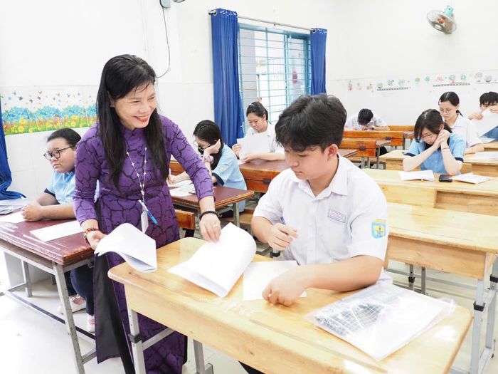  Cán bộ coi thi phát giấy thi cho thí sinh. Ảnh: THU TÂM. 