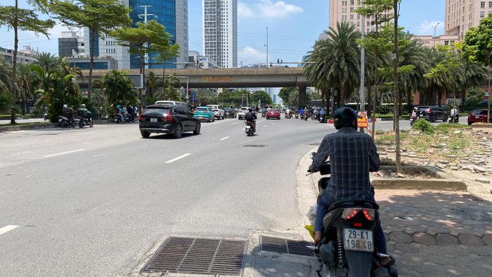 Người tham gia giao thông dừng xe trú nắng dưới các bóng râm khi chờ đèn tín hiệu giao thông tại ngã tư đường Dương Đình Nghệ và Vành đai 3 (Hà Nội). Ảnh: PHÚC HẬU