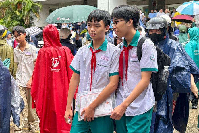  Các thí sinh vui vẻ ra về sau môn thi cuối cùng trong cơn mưa vừa tạnh tại điểm thi Trường THPT Nguyễn Hữu Thọ, phường Xóm Chiếu (TPHCM) ẢNH: HOÀNG HÙNG 