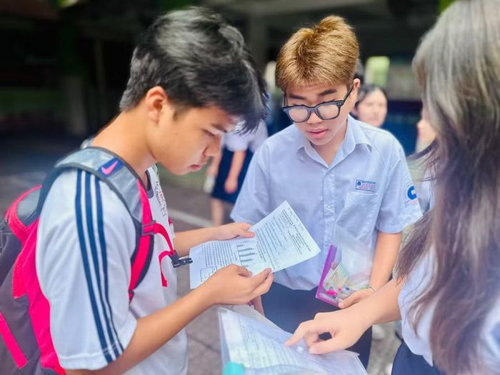 Viết Khôi (giữa) cùng bạn trao đổi về đề thi Toán. Ảnh: Thùy Linh.