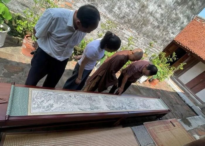 Thượng tọa Thích Tục Phương - trụ trì chùa Trăm Gian (Hải Phòng) cùng các nghệ nhân Thanh Liễu xem tác phẩm bản in “Trúc Lâm đại sĩ xuất sơn đồ”.