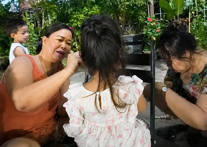 Bé gái chừng 3 tuổi được người dân hỗ trợ bón cháo. Theo người dân địa phương, người mẹ không muốn chia sẻ về hành trình của mình.