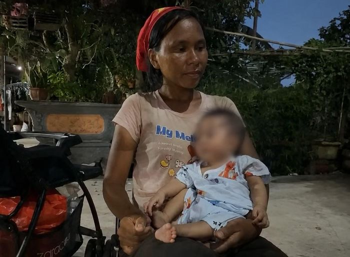 Bé trai 6 tháng tuổi được người mẹ cho bú sữa bình.