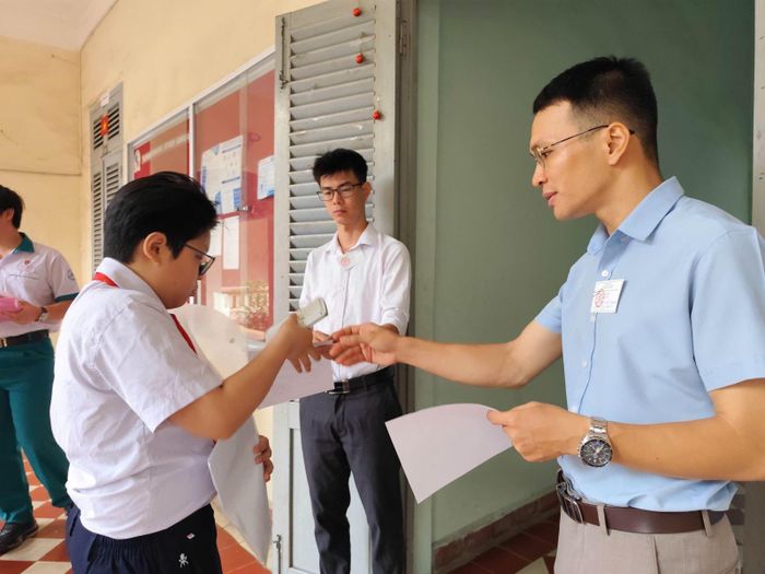 Giám thị tại điểm trường Lê Hồng Phong kiểm tra thông tin thí sinh.