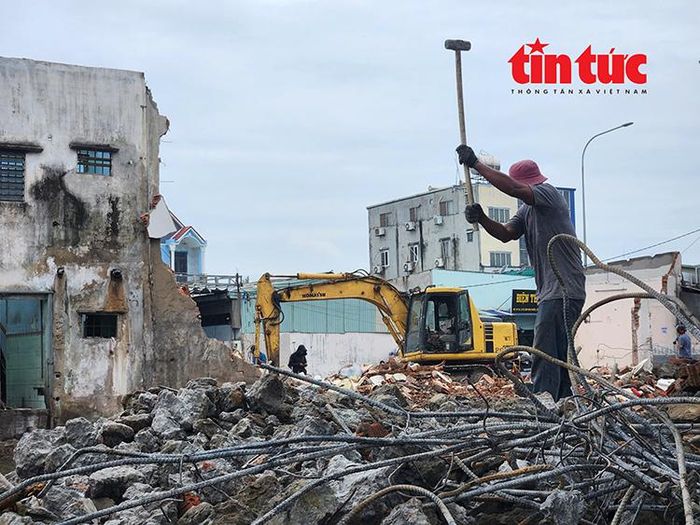 Nhiều máy móc cùng công nhân đang tất bật tháo dỡ những căn nhà nằm trong diện giải tỏa trên Quốc lộ 13.