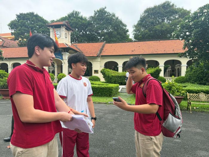Các bạn học sinh trường Việt Úc trao đổi đáp án môn Toán ngay trước cổng điểm thi sau khi kết thúc giờ làm bài.