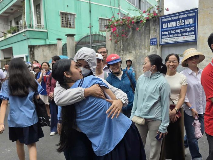 Học sinh vui vẻ ngã vào vòng tay mẹ sau khi kết thúc môn Toán tại trường THCS Lương Định Của.