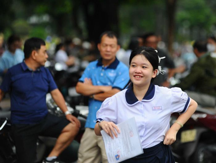 Một thí sinh vui vẻ bước ra khỏi phòng thi trong vòng tay chờ đợi của cha mẹ.