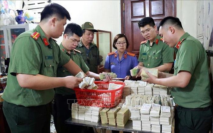 Lực lượng chức năng tỉnh Lạng Sơn khám xét, thu thập tài liệu, tiền mặt phục vụ công tác điều tra. Ảnh: TTXVN phát