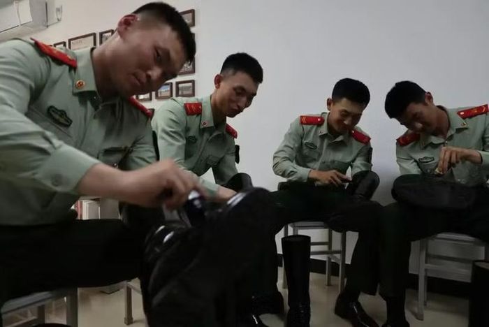 Một nhóm binh sĩ đang đánh bóng giày để đảm bảo chúng sạch bong trước khi diễu binh. Ảnh: bjd.com