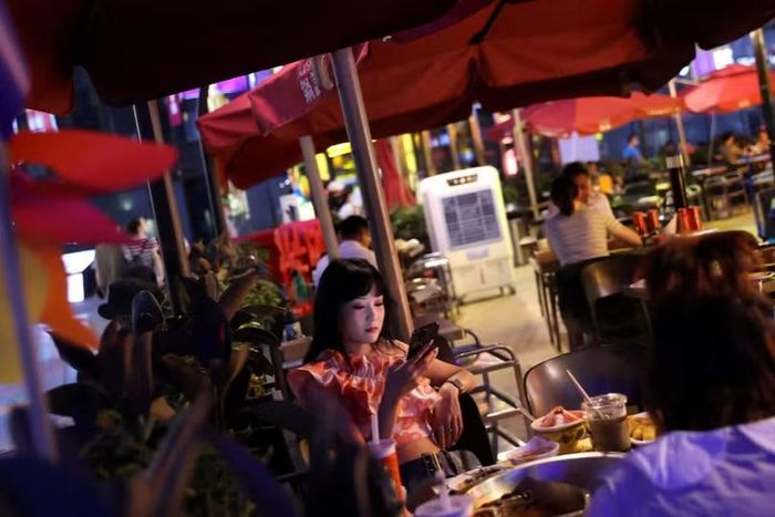 Khách hàng dùng bữa tại một nhà hàng trong khu mua sắm ở Bắc Kinh, Trung Quốc, ngày 25/7/2022. Ảnh: Reuters.