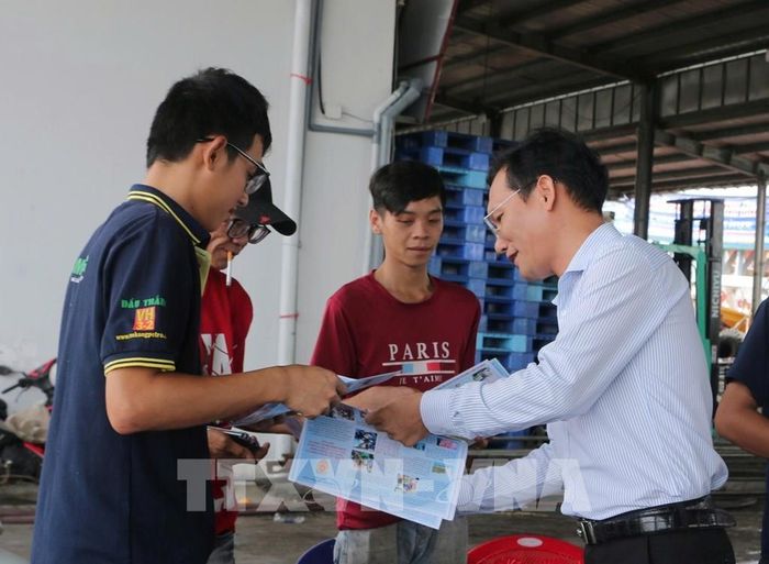 Cán bộ tuyên truyền phổ biến pháp luật về phòng, chống khai thác IUU ra tận cảng cá Sông Đốc gặp gỡ, tuyên truyền ngư dân thực hiện nghiêm các qui định chống khai thác IUU. Ảnh: Tuấn Kiệt – TTXVN