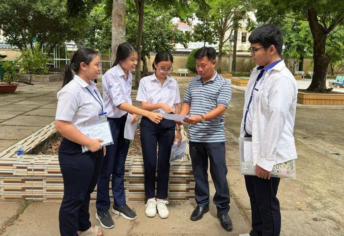 Thí sinh tại điểm thi Trường THPT chuyên Huỳnh Mẫn Đạt, phường Rạch Giá chia sẻ thông tin môn thi Ngữ văn cùng phụ huynh và các bạn. Ảnh: CẨM TÚ