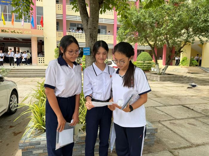 Em Trần Thị Yến Nhung (bìa trái), lớp 9/1, Trường THCS Nguyễn Trãi cùng các bạn xem lại đề thi tiếng Anh. Ảnh: CẨM TÚ