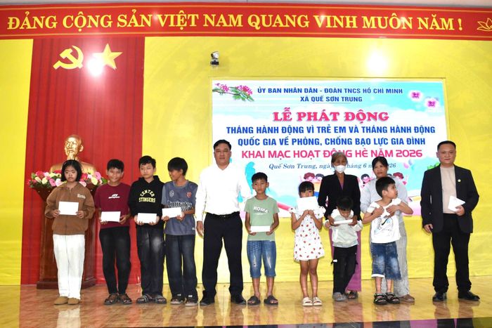 Ông Phan Duy Thanh, Phó Chủ tịch UBND xã Quế Sơn Trung (thứ 5, trái sang) và Ông Trần Văn Tuấn, Chủ tịch Tập đoàn Thái Bảo (ngoài cùng, bên phải) tặng cho trẻ em trên địa bàn. Ảnh: DUY THÁI