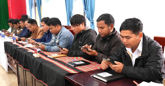 Cán bộ thôn xã Avương sử dụng điện thoại thông minh quét mã QR để cập nhật tài liệu tại các cuộc họp và đẩy mạnh ứng dụng công nghệ số trong hoạt động tại cơ sở. Ảnh: HIỀN THÚY