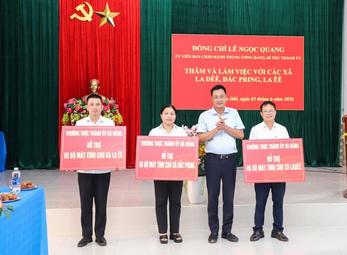 Thay mặt Thường trực Thành ủy, Bí thư Thành ủy Lê Ngọc Quang trao cho mỗi xã 5 bộ máy vi tính. Ảnh: NGỌC PHÚ