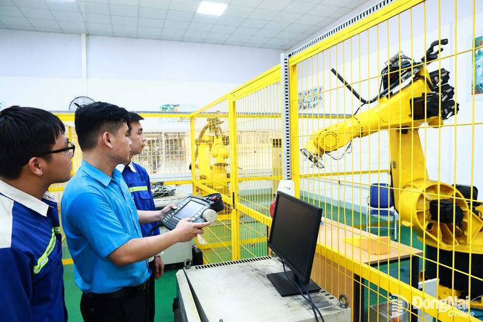 Giảng viên Trường cao đẳng Công nghệ quốc tế Lilama 2 (xã Long Phước) hướng dẫn sinh viên vận hành robot công nghiệp. Ảnh: Công Nghĩa