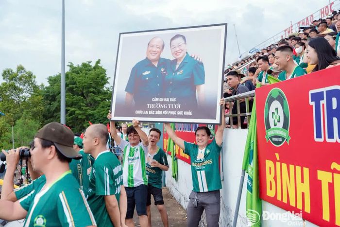 Ảnh 2 vợ chồng Cựu chiến binh Phạm Công Trường và Nguyễn Thị Hồng Tươi được CĐV trịnh trọng dương cao trên khán đài - Ảnh: Nguyễn Tấn