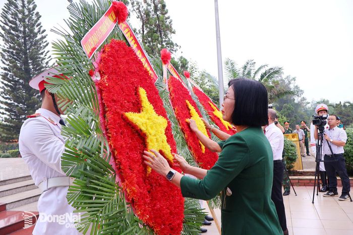Thành ủy viên, Phó Chủ tịch UBND thành phố, Trưởng ban Chỉ đạo 515 thành phố Đồng Nai Nguyễn Thị Hoàng và đại biểu chỉnh hoa dâng viếng liệt sĩ trước khi thực hiện nhiệm vụ. Ảnh: Nguyệt Hà