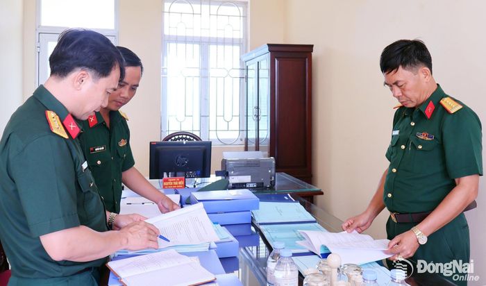 Thành viên đoàn kiểm tra hồ sơ sổ sách công tác tham mưu, huấn luyện. Ảnh: Nguyệt Hà