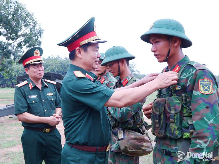 Thủ trưởng Tổng cục Chính trị chỉnh sửa quân phục cho chiến sĩ mới đang huấn luyện trên thao trường. Ảnh: Nguyệt Hà