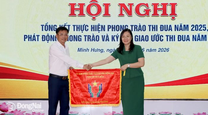 Cụm trưởng Cụm thi đua số 6 thành phố Đồng Nai năm 2025 trao cờ luân lưu Cụm trưởng Cụm thi đua số 6 năm 2026 cho phường Chơn Thành. Ảnh: Trung Quang