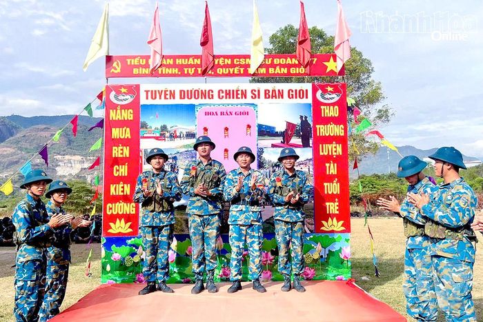 Chỉ huy đại đội trao "hoa bắn giỏi" động viên chiến sĩ có thành tích tốt trong bắn tổng hợp súng tiểu liên AK bài 1.