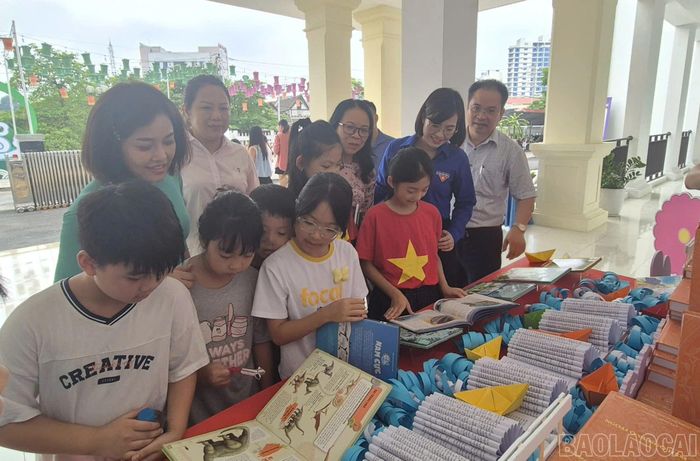 Đại biểu và thiếu nhi tham quan mô hình xếp sách nghệ thuật.