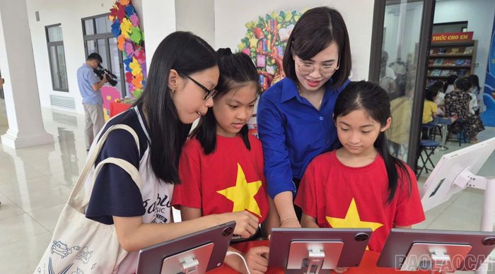 Bà Dương Thị Vui hướng dẫn thiếu nhi trải nghiệm "Không gian tri thức số".